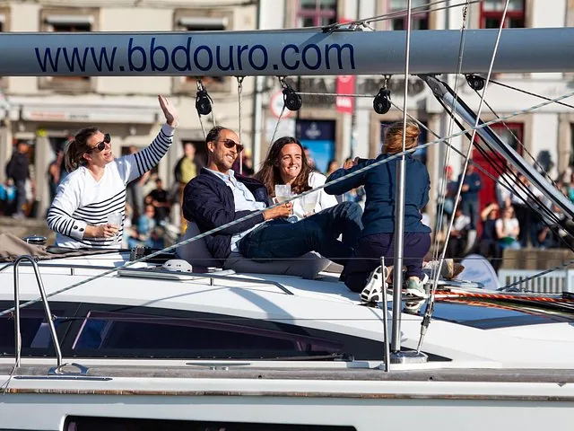 Group of friends relaxing and enjoying drinks on a sailboat deck