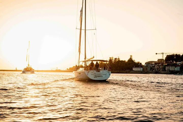 Sailboats cruising on the Douro River as the sun sets