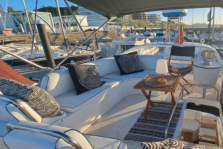 Comfortable seating area on a yacht with black and white cushions and small tables.